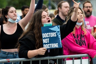 A protester shouts slogans and holds a placard reading "Doctors not doctrine" during an abortion related demonstration in front of the Supreme Court.