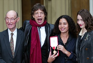 Mick Jagger December 2003 Rollign STones member collects his knighthood from Prince Charles at Buckingham Palace with his father dad Joe Jagger 92 and daughter s Karis Jagger holding medal and Elizabe...