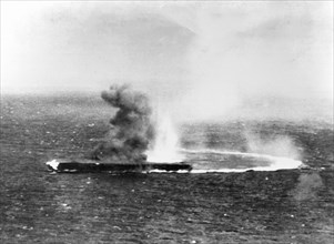 Japanese aircraft carrier Shokaku under dive bombing attacks by USS Yorktown (CV-5) planes, during the morning of 8 May 1942. Flames are visible from a bomb hit on her forecastle.