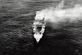 The burning Japanese aircraft carrier Hiryu, photographed by a Yokosuka B4Y aircraft from the carrier Hosho shortly after sunrise on 5 June 1942. Hiryu sank a few hours later. Note the collapsed fligh...