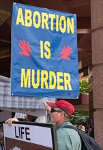 MINNEAPOLIS, MN/USA - JUNE 30, 2018: An unidentified individual holding sign in a public anti-abortion demonstration.