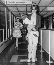 Rolling Stones lead singer Mick Jagger with his wife Bianca and daughter Jade leaving London's Heathrow Airport in 1975.