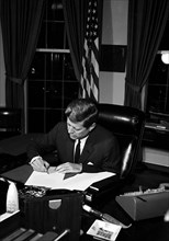 23 October 1962
Proclamation signing, Interdiction of the Delivery of Offensive Missiles to Cuba, 7:05PM.
[White spotting throughout negative.]

Please credit "Cecil Stoughton. White House Photographs...