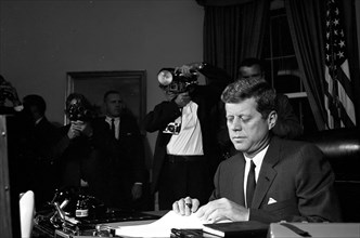 23 October 1962
Proclamation signing, Interdiction of the Delivery of Offensive Missiles to Cuba, 7:05PM.
[White spotting throughout negative.]

Please credit "Cecil Stoughton. White House Photographs...