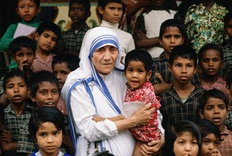 Mother Teresa accompanied by children at her mission in Calcutta, India