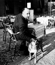 Fashion designer Christian Dior at a cafe with his dog