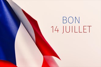 some french flags and the text text bon 14 juillet, happy 14 july, the national day of France written in French, against an off-white background