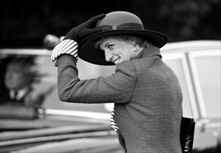 Princess Diana holds on to Her hat.