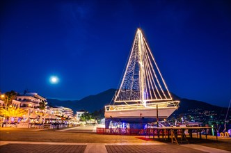 Iconic view of a decorated wooden sailing boat during Christmas period against a starry night in Kalamata city, Messenia, Greece