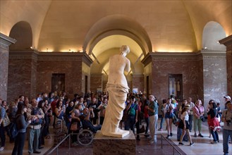 People around Venus de Milo (Aphrodite of Milos), one of the most famous ancient Greek sculpture, on display at the Louvre Museum in Paris, France