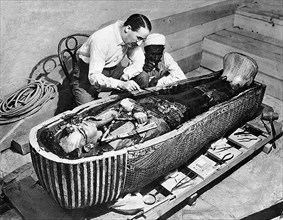 Tutankhamun tomb. Howard Carter examining the sarcophagus from the tomb of King Tutankhamun, Luxor, Egypt. Photo taken in 1922