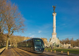 Bordeaux, Gironde Department, Aquitaine, France.  Tram of the city transport system passing Monument to the Girondins on Place des Quinconces. The his