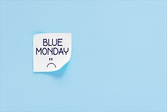 Blue monday text with sad smiley face. Sticker on blue wall. Most depressing and saddest day of the year. Blue monday concept. Copy space.