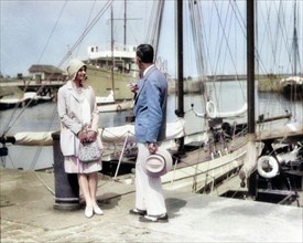 1920s WELL DRESSED STYLISH COUPLE STANDING TALKING TOGETHER MAN SMOKING CIGARETTE YACHT MARINA DEAUVILLE FRANCE  - y1064c HAR001 HARS NOSTALGIA OLD FASHION 1 STYLE FRANCE VACATION YACHT JOY LIFESTYLE ...