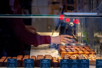 Picture of a shop, a bakery, selling Caneles Bordeaux, in the city center of Bordeaux, France. A canelé is a small French pastry flavored with rum and