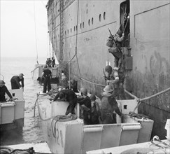 American troops climb into assault landing craft from the liner REINA DEL PACIFICO during Operation 'Torch', the Allied landings in North Africa, November 1942. American troops manning their landing c...
