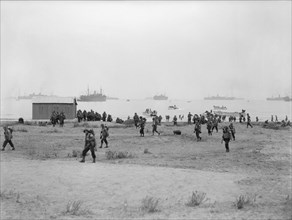 The Royal Navy during the Second World War- Operation Torch, North Africa, November 1942 American troops making their way inland after landing at Arzeu. Several small landing craft can be seen in the ...