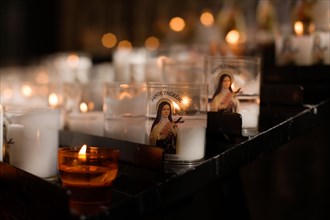 Candles burning in prayer to Saint Therese of Lisieux, known as 'The Little Flower', in the Cathedral in Rouen, France