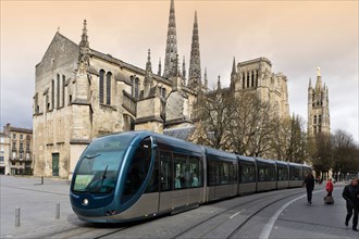 Modern tram in front of St Andre Cathedral and Pey Berland Tower in the city centre, Bordeaux, Aquitaine, France