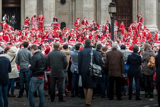 London, UK. 14th December, 2013.  Hundreds of Santas gathering on the steps of St Pauls Cathedral before they march off to meet up with groups of other Santas to celebrate the annual Santacon.  Photog...