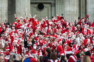 London, UK. 14th December, 2013.  Hundreds of Santas gathering on the steps of St Pauls Cathedral before they march off to meet up with groups of other Santas to celebrate the annual Santacon.  Photog...