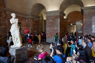 Venus of Milo statue with tourists in Louvre museum, Paris