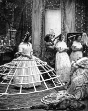 HOOPED SKIRT (aka Cage Crinoline) Part of a comic French series of photos  about 1860 showing the stages of putting on a crinoline skirt supported by a cage