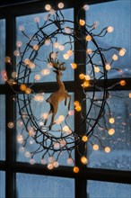 Christmas lights hanging on window indoors, Iceland