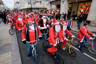 BMX bikers dressed as Santa Clause ride down Oxford Street