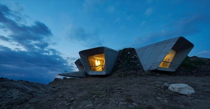 View towards picture windows at dusk. Messner Mountain Museum Corones, Mount Kronplatz, Italy. Architect: Zaha Hadid Architects,