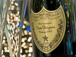 Dom Perignon vintage 2002 luxury champagne and glasses with sparkling lights in background