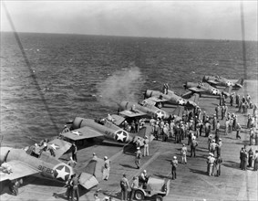 Testing machine guns of Grumman F4F-4 Wildcat fighters aboard USS Ranger (CV-4), while en route from the U.S. to North African waters, circa early November 1942. Note the special markings used during ...