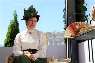 French woman dressed like a Parisian of the early 20th century posing during Moscow historical festival Times and epochs