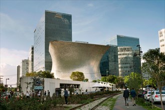 Urban landscape in Polanco district with people walking and Soumaya Museum in the background. Mexico City, CDMX, Mexico. Jun 2019