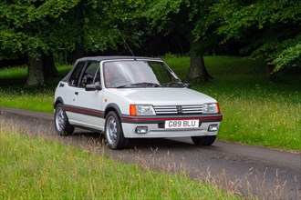 A 1990 90s white Peugeot 205 Cti Cabriolet Petrol at ‘The Cars the Star Show” in Holker Hall & Gardens, Grange-over-Sands, UK