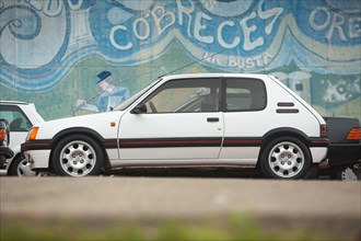 Cobreces, Spain - August 14, 2021: Car show in Cobreces. Original white Peugeot 205 GTI side face. The Peugeot 205 is a car produced by the French man