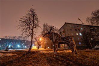 Moose land art sculpture in city at night lights