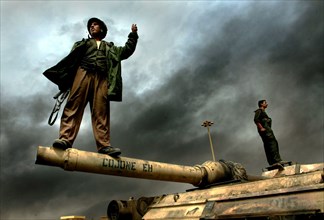 Iraq War 2003 Baghdad An Iraqi soldier stands proudly on the barrel of what is thought to be a destroyed American tank on the outskirts of the city