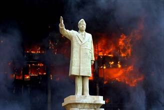 Iraq War April 2003 Baghdad American marines takeup postions in Eastern Baghdad Our Picture Shows Saddam s son Uday office in flames as his father s statue stands in front