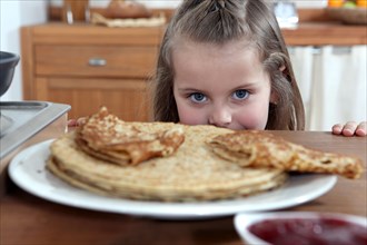 Greedy girl looking at pancakes
