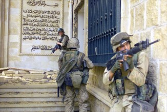US Marines cover each other as they prepare to enter one of Saddam Hussein's palaces during Operation Iraqi Freedom April 9, 2003 in Baghdad, Iraq.