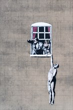 The infamous work by Banksy known as Well Hung Lover, Naked Man Hanging From Window, or just Naked Man. This piece is viewed from Park Street, Bristol.