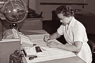 Katherine Johnson, NASA research mathematician, at her desk at NASA Langley Research Center with a globe, or "Celestial Training Device," in 1962.