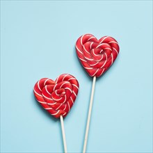 Valentine's card. Two lollipops candy as heart on blue background. Funny concept.