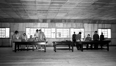 General William K. Harrison, Jr., seated at left, and North Korean General Nam Il, seated at right, sign armistice documents in Armistice Hall in Panmunjom, a no-man's-land between the Koreas. The 195...