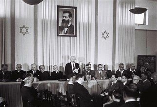David Ben Gurion, who was to become Israel's first Prime Minister, reads the Israeli Declaration of Independence May 14, 1948 at the museum in Tel Aviv, during the ceremony founding the State of Israe...