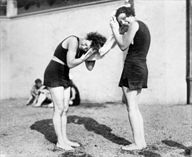 Two women in bathing costumes drying their hair, circa 1925
