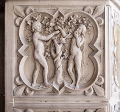 Relief carving of Adam, Eve and the Tree of Knowledge. Eve eats an apple with Adam looking on with a serpent