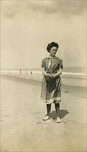 Antique 1908 photograph, woman on beach in Victorian style bathing suit. Location: New England, USA. SOURCE: ORIGINAL PHOTOGRAPHIC PRINT.