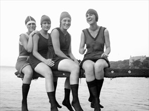 A group of young women happily pose on a diving board overlooking Lake Mendota in Madison, Wisconsin.